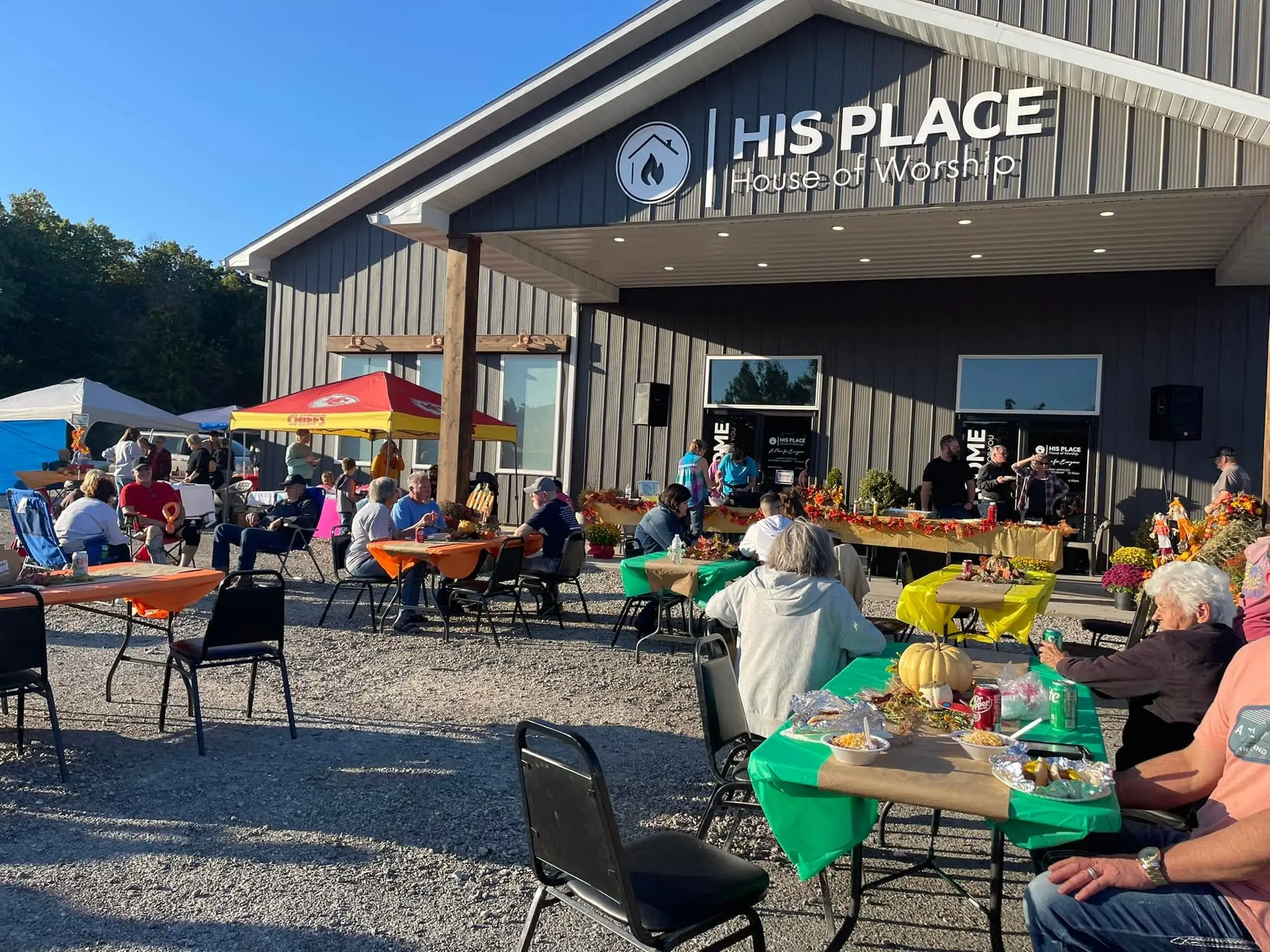 The His Place House of Worship building, with families at tables out front