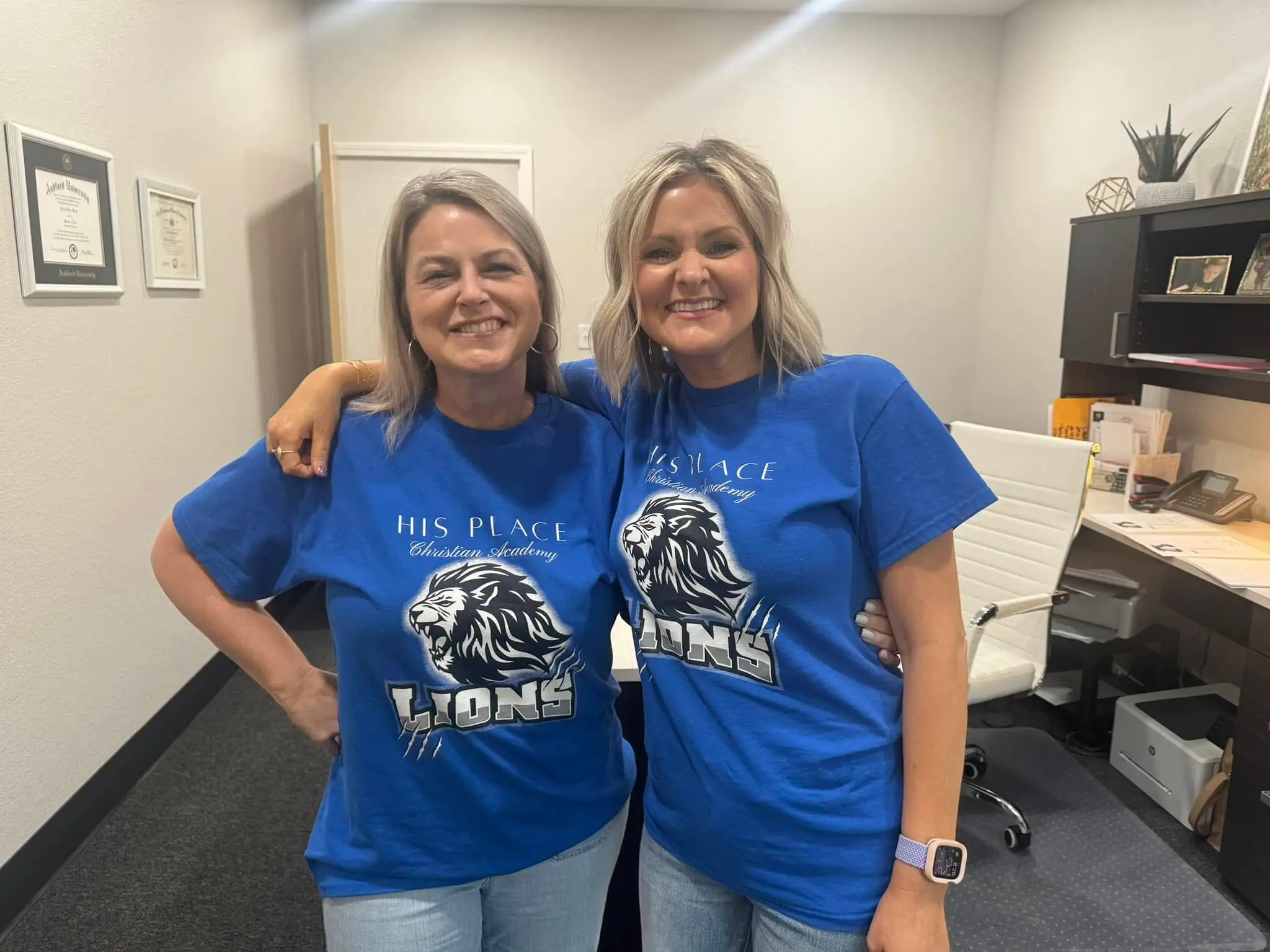 Two HPCA staff members in Lions shirts