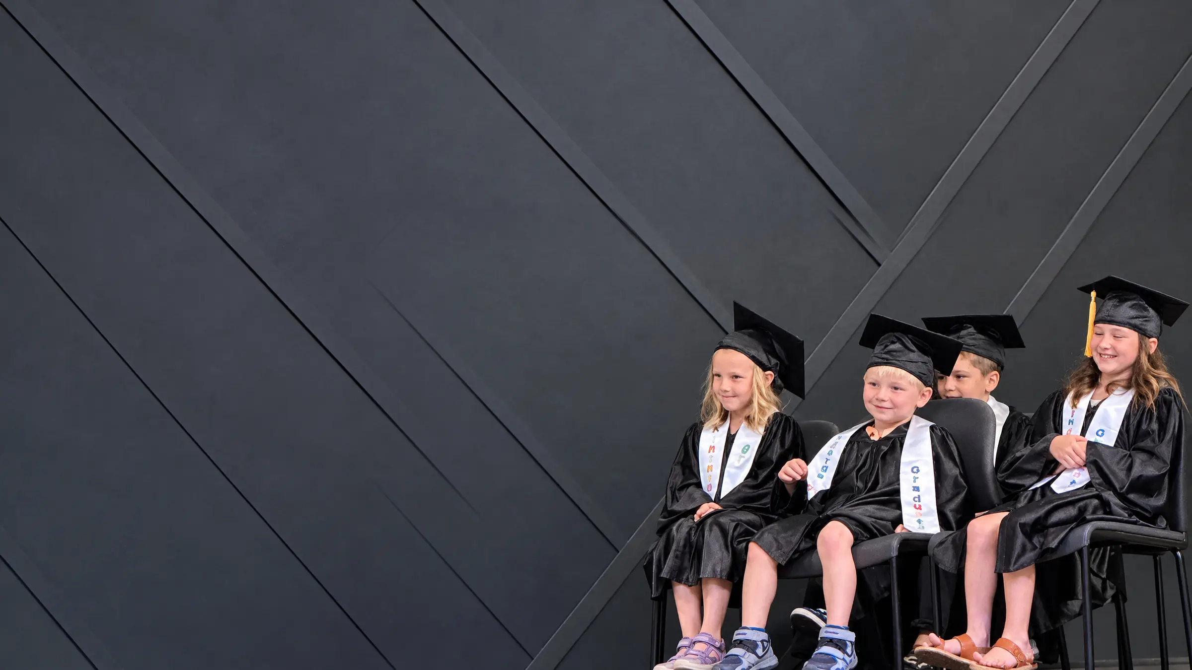 Young HPCA graduates smiling in their caps and gowns